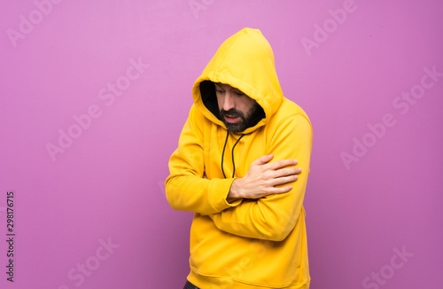 Handsome man with yellow sweatshirt freezing