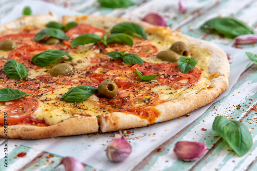 Freshly made wood fired pizza viewed from above on rustic turquoise boards Freshly made wood fired pizza viewed from above on rustic turquoise boards