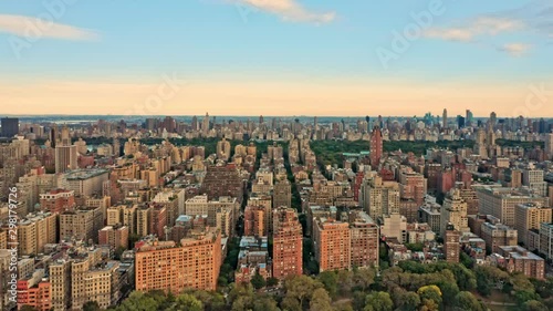 Aerial drone footage of New York midtown skyline at sunset viewed from above upper West Side neighborhood, with slow camera rotation