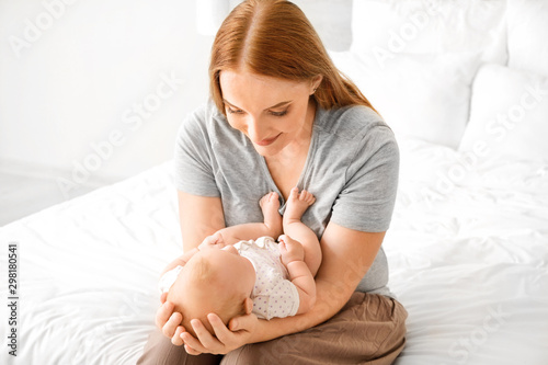 Mother with cute baby in bedroom