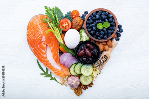 Heart shape of ketogenic low carbs diet concept. Ingredients for healthy foods selection on white wooden background. Balanced healthy ingredients of unsaturated fats for the heart and blood vessels.