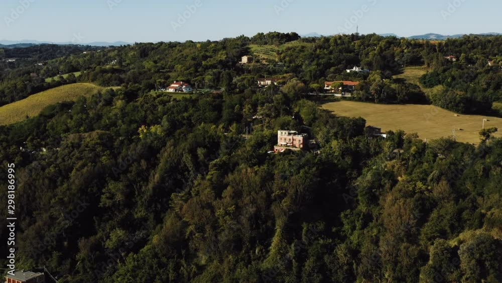Drone slowly zooming in above magnificent peaceful houses surrounded by green tree hills in Italy on sunny summer day. Drone slowly zooming in above magnificent peaceful houses surrounded by green tree hills in Italy on sunny summer day.