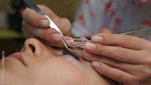 Beautiful Woman with long eyelashes in a beauty salon. Eyelash extension procedure.