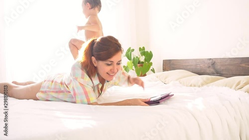 Mom and son watch tablet in bedroom