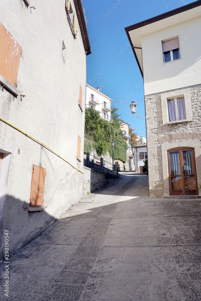 Fototapeta premium Narrow steep street with old houses in the old part of the San Marino city