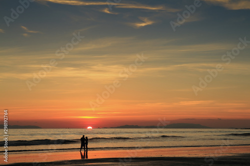 The perfect sunset ,a silhouetted couple take in the last vestiges of the day on a the beach,koh Phayam,ranong thailand © changphoto