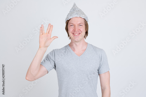 Photography Happy young man wearing tin foil hat as conspiracy theory concept showing Vulcan