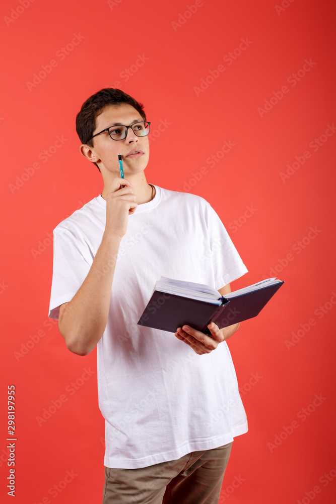 Conceived student in glasses holding a notebook and looking Conceived student in glasses holding a notebook and looking