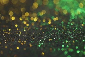 Wallpaper phone shining glitter.New Year and Christmas  background. Gold and green glitter macro background with shining bokeh on a black background. Shining texture