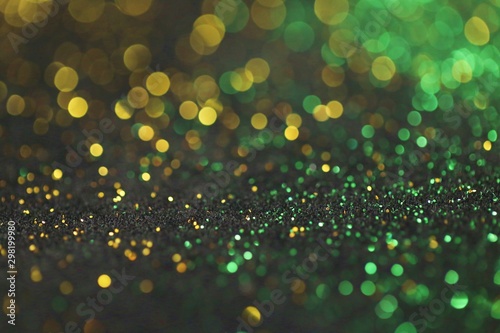 Wallpaper phone shining glitter.New Year and Christmas  background. Gold and green glitter macro background with shining bokeh on a black background. Shining texture
