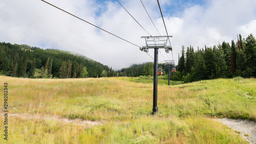 Gondola lifts going up the mountain in northern Montana on a bright summer day.