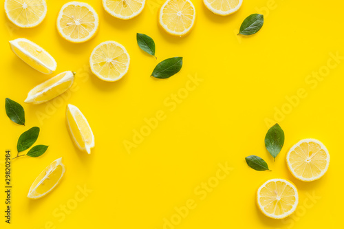 Fruit frame. Lemons and leaves on yellow background top view copy space