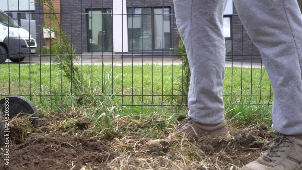 skilled worker loosens soil with manual tractor in private house yard. Gimbal skilled worker loosens soil with manual tractor in private house yard. Gimbal