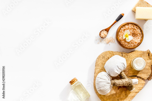 Spa set with massage herbal balls in wellness salon on white background top view frame space for text