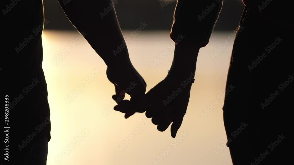 silhouette lovers hold hands together love each other forever during the sunset golden light, romantic concept.