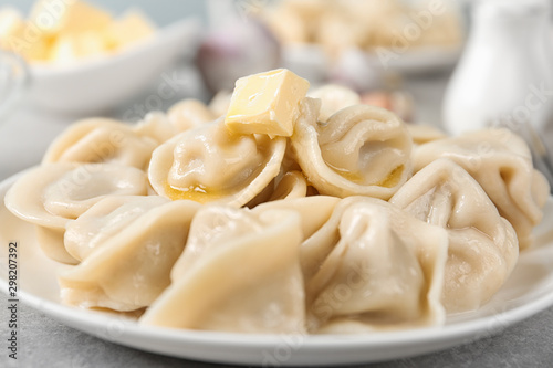 Tasty dumplings with butter on light grey table  closeup