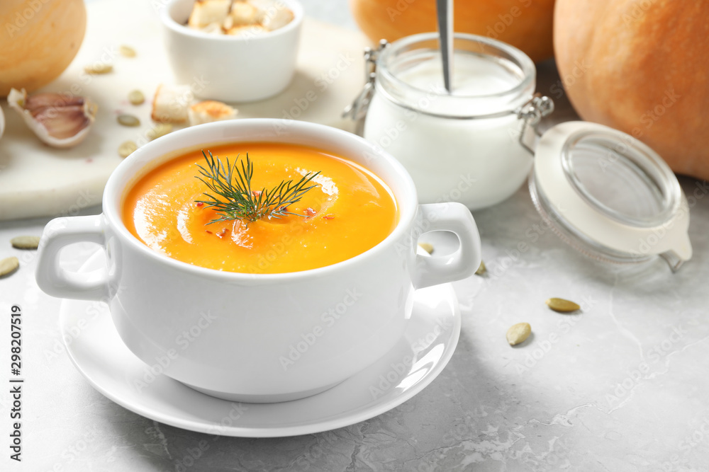 Delicious pumpkin soup in bowl on marble table Delicious pumpkin soup in bowl on marble table