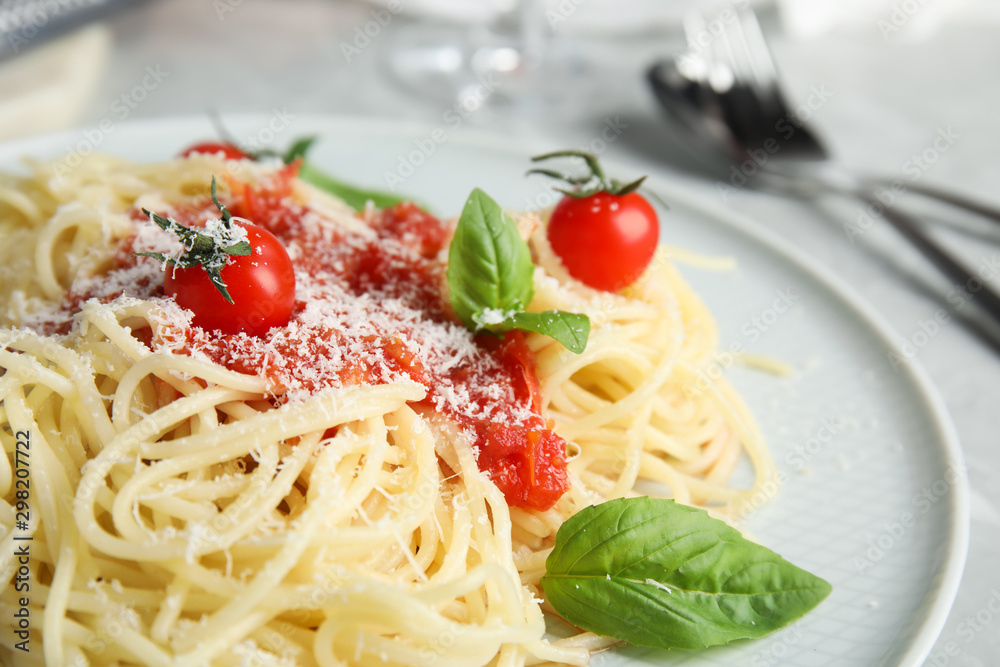 Tasty pasta with tomatoes, cheese and basil on table, closeup