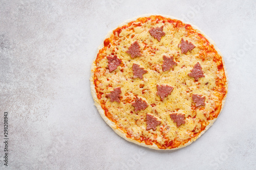 Pizza decorated with pepperoni shaped as Christmas trees.