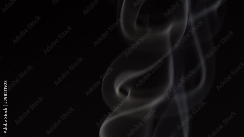 White smoke on black background in slow motion. White steam spins and rises White smoke on black background in slow motion. White steam spins and rises