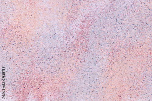 A background of a mixture of grainy orange, blue, lilac, crimson, pink sand on white background