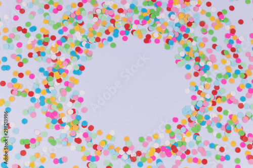 Multicolored colorful bright round confetti scattered around on white background