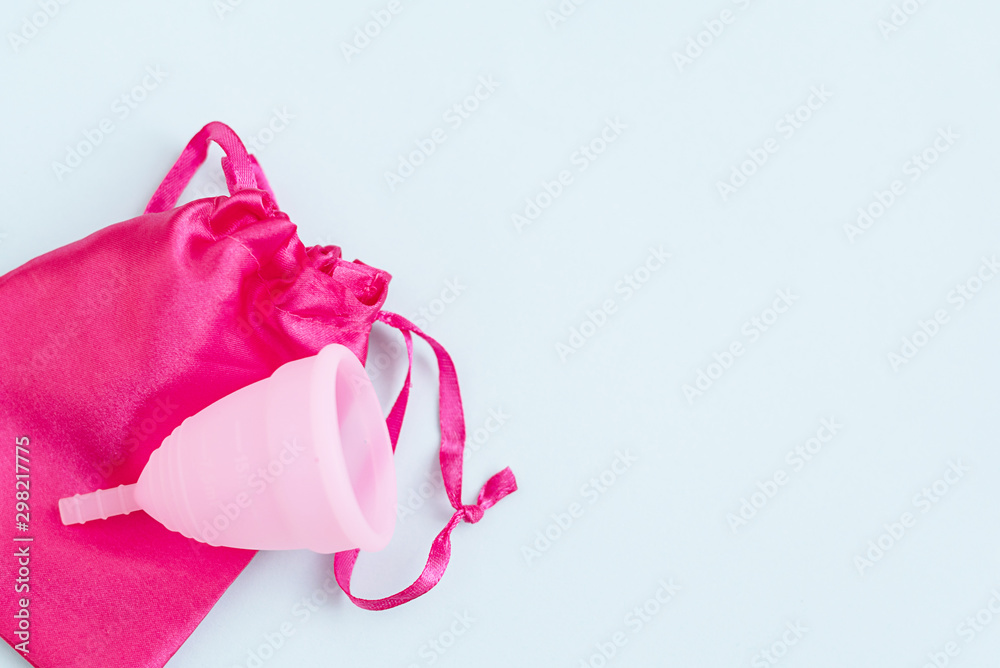 pink menstrual Cup and bag on blue background. woman period concept. pink menstrual Cup and bag on blue background. woman period concept.