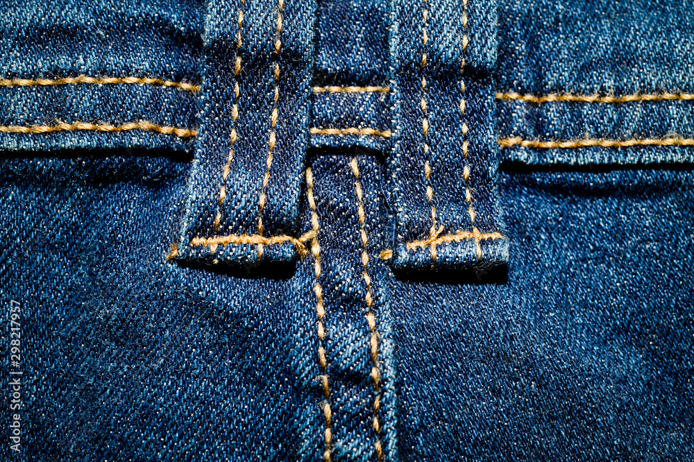 Close-up texture of blue denim stitched with orange thread Close-up texture of blue denim stitched with orange thread