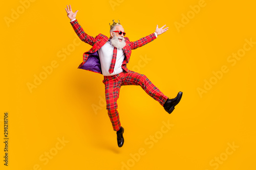 Full length body size view of his he nice handsome attractive cheerful cheery carefree gray-haired man jumping having fun rejoice isolated over bright vivid shine vibrant yellow color background