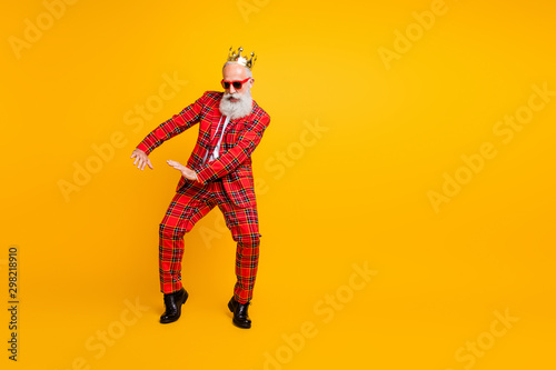 Full body photo of funny grandpa white beard dancing strange youngster moves little drunk wear crown sun specs gingham red costume isolated yellow color background © deagreez