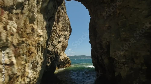 Flight extreme flight inside rock tunnel. Ocean coastline cliff with whole. Summer beautiful day sunny. Asia Russia extreme sports travel Vladivostok photo