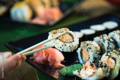 Sushi Set. Various rolls on a wooden plate. On dark rustic background