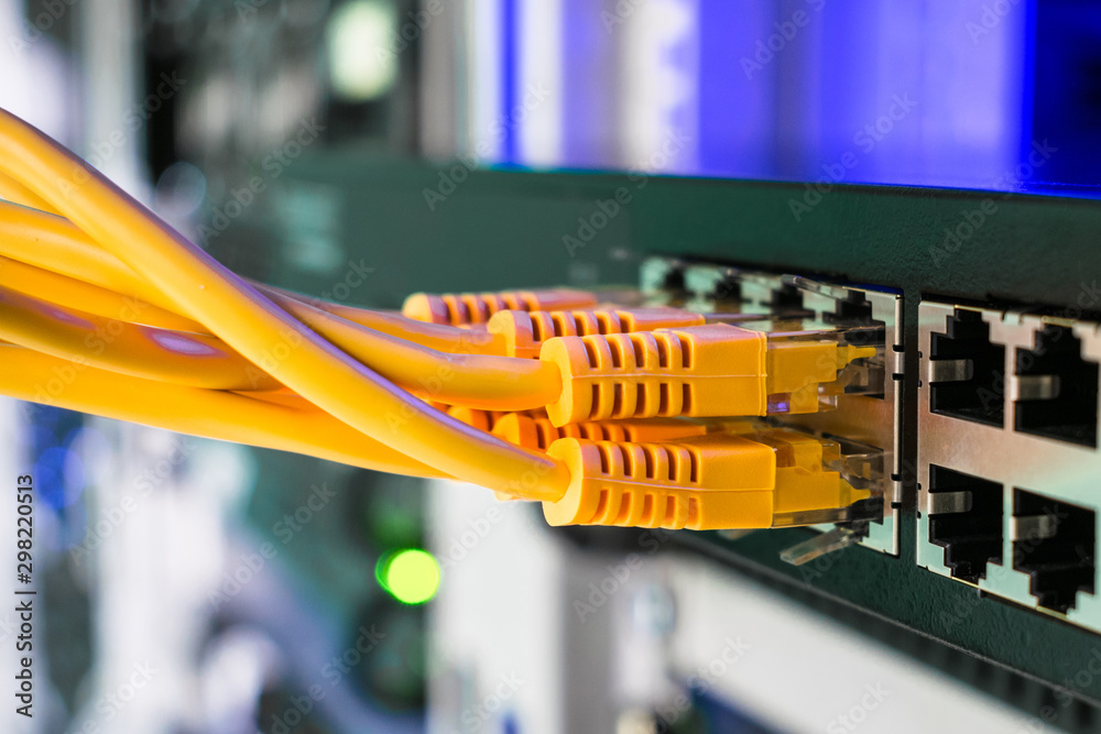 Information technology concept. Utp cable connects to the interfaces of the  main office router. Many yellow internet wires connect to the network  switch in the server room. Stock Photo | Adobe Stock