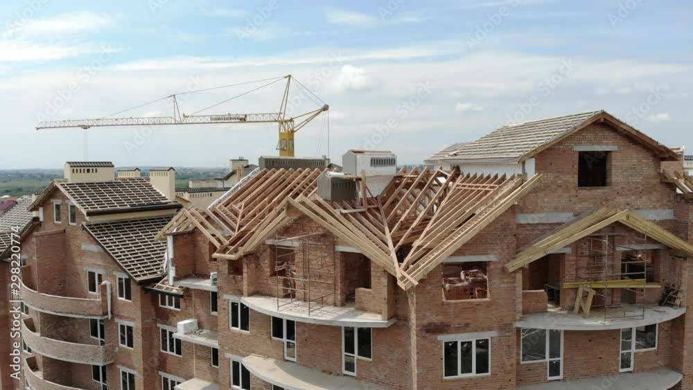 Aerial Construction of a brick house. Installation of wooden roof Aerial Construction of a brick house. Installation of wooden roof