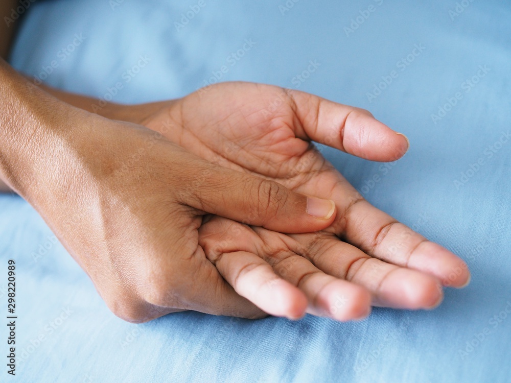 Thai person on blue bed and palm massage to relieve acute hand pain, Medical health concept. Thai person on blue bed and palm massage to relieve acute hand pain, Medical health concept.