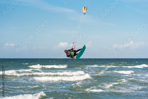 Jump of a Kiteboarder in the Baltic Sea at the beach of Flügge on the island Fehmarn in the north of Germany © ksl