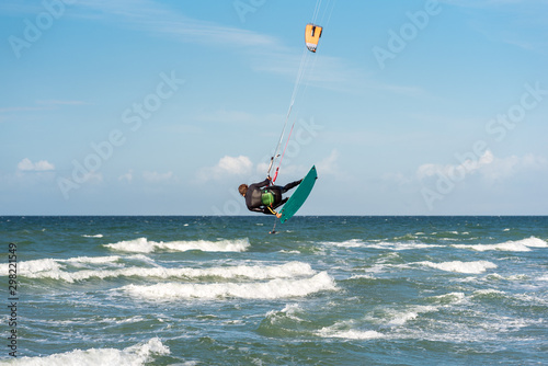 Fototapeta Naklejka Na Ścianę i Meble -  Jump of a Kiteboarder in the Baltic Sea at the beach of Flügge on the island Fehmarn in the north of Germany