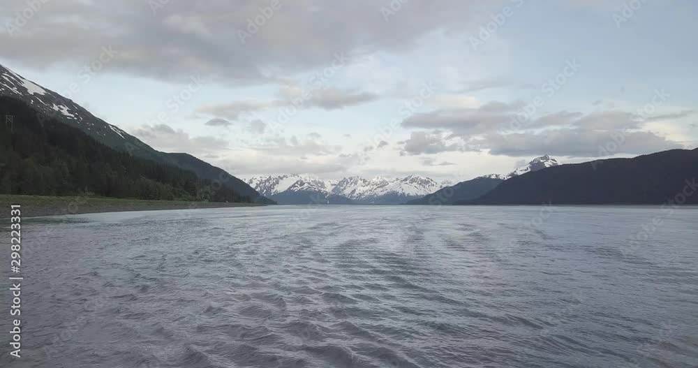Drone shot flying over the calm waters of the Cook Inlet in South-Central Alaska. Majestic, Alaskan mountains can be seen in the distance, and on both sides of the inlet. Drone shot flying over the calm waters of the Cook Inlet in South-Central Alaska. Majestic, Alaskan mountains can be seen in the distance, and on both sides of the inlet.