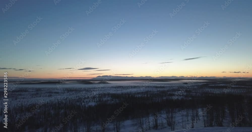 Drone Shot flying over an Alaskan countryside towards a beautiful sunset on the horizon. Drone Shot flying over an Alaskan countryside towards a beautiful sunset on the horizon.