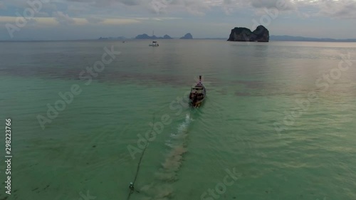 ARIAL: longtail boat in thailand, during sunrise photo