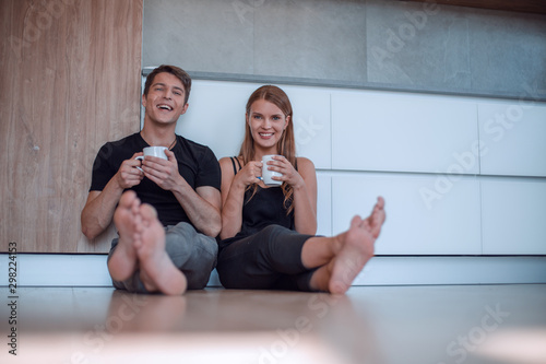 young couple sitting on the floor in new kitchen. photo