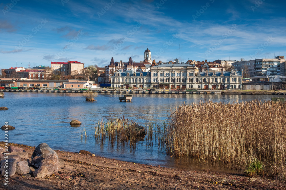 Naklejka premium Panorama of the embankment with ancient beautiful buildings of the city of the middle-century city of Vyborg in Russia on an autumn sunny day
