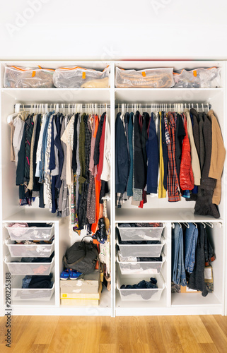 Colored clothes in the closet. Storage of clothes and things in the closet