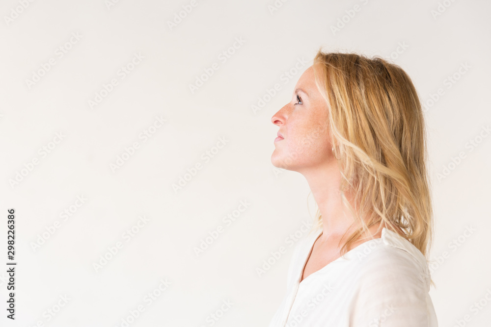 Profile of beautiful woman looking away. Side view of attractive young blonde woman looking up isolated on grey background. Beauty concept Profile of beautiful woman looking away. Side view of attractive young blonde woman looking up isolated on grey background. Beauty concept