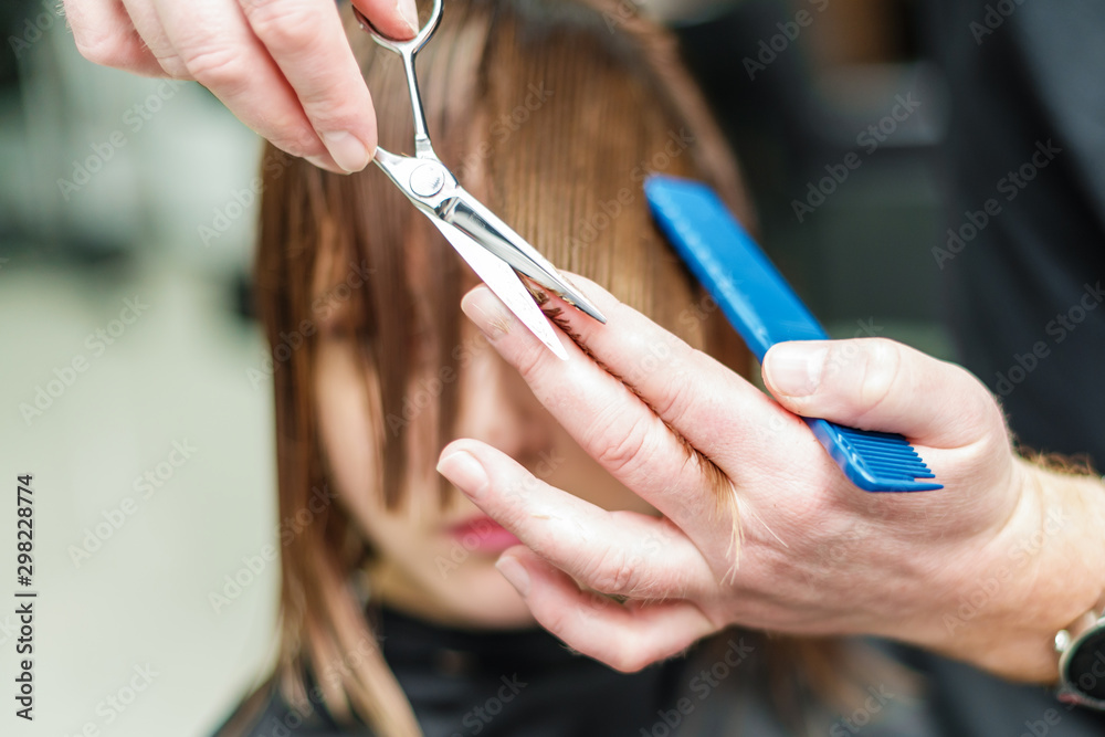 Hands of hairdresser is cuting hair close up. Hair stylist cuts hair of woman close up. Hands of hairdresser is cuting hair close up. Hair stylist cuts hair of woman close up.