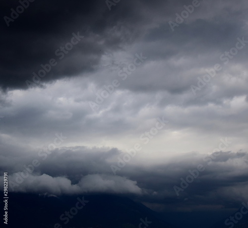 Dunkle bedrohliche Gewitterwolken und Regenwolken am grauen Himmel