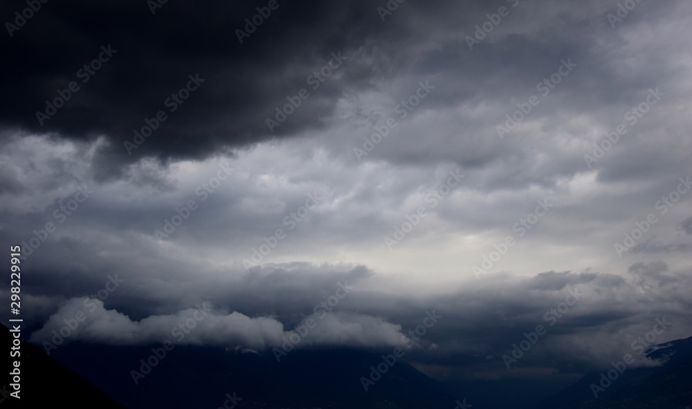 Dunkle bedrohliche Gewitterwolken und Regenwolken am grauen Himmel