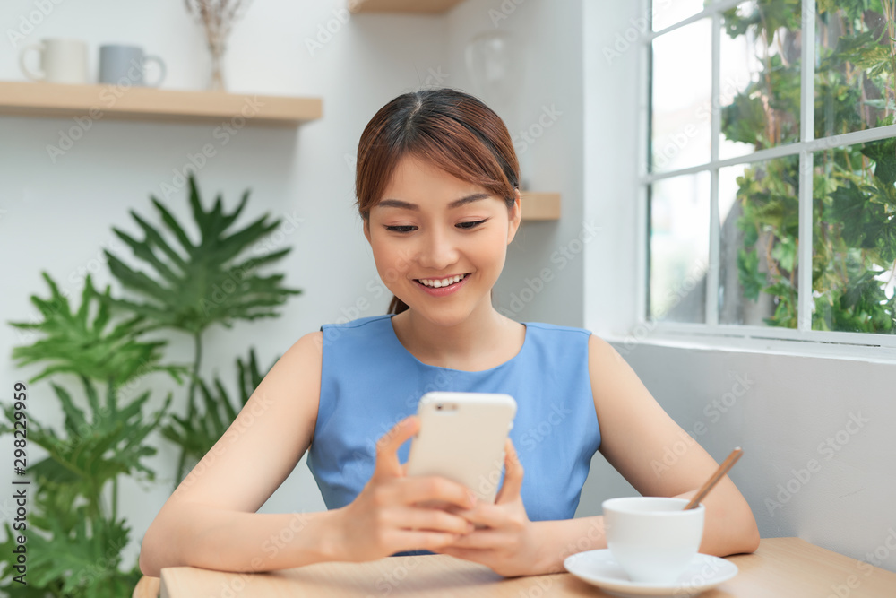 Portrait of young Asian woman using phone while drinking coffee Portrait of young Asian woman using phone while drinking coffee