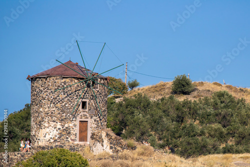 Old wind mill close-up. Historic place and sky. Among the bushes and grasses