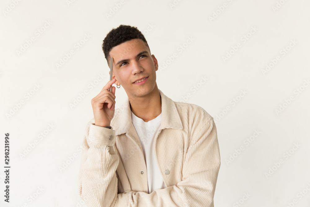 Thoughtful man holding pen and looking up. Portrait of pensive handsome young man holding pen near forehead and looking away. Facial expression concept Thoughtful man holding pen and looking up. Portrait of pensive handsome young man holding pen near forehead and looking away. Facial expression concept